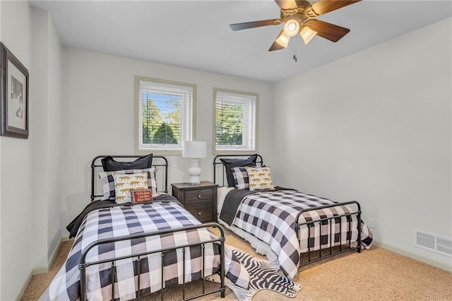 carpeted bedroom with visible vents, a ceiling fan, and baseboards