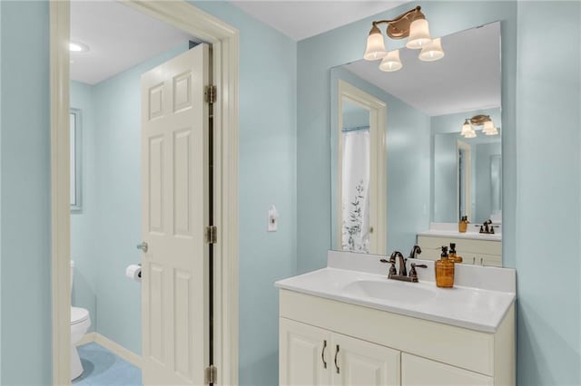 full bathroom with vanity, toilet, and baseboards