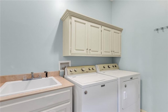 laundry area featuring washer and dryer, cabinet space, and a sink