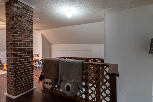 interior space with a textured ceiling and wood finished floors