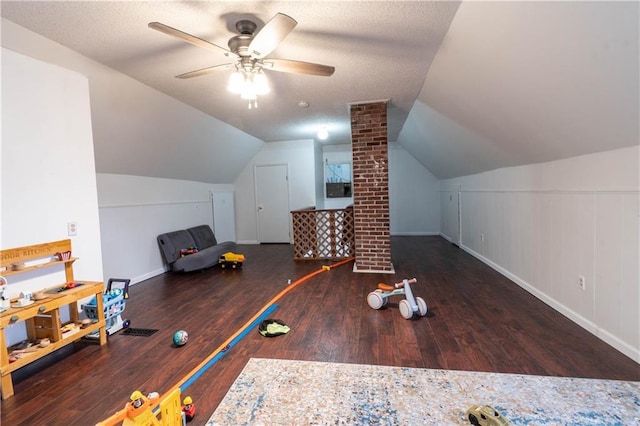 additional living space featuring vaulted ceiling, a textured ceiling, wood finished floors, and a ceiling fan