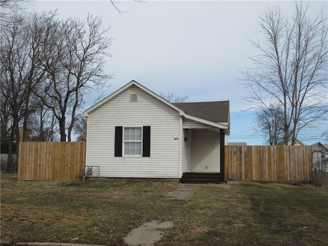 view of front facade with entry steps, fence, and a front lawn