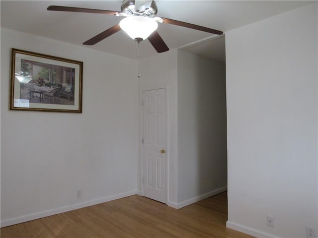 empty room featuring wood finished floors, a ceiling fan, and baseboards