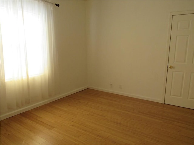 empty room with light wood-style floors and baseboards