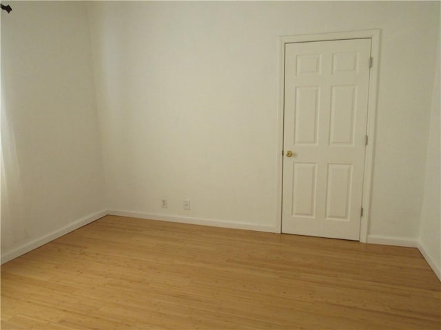 spare room with light wood-style flooring and baseboards