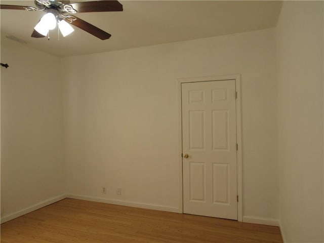 spare room with ceiling fan, light wood-style flooring, and baseboards