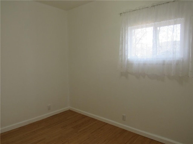 empty room featuring baseboards and wood finished floors