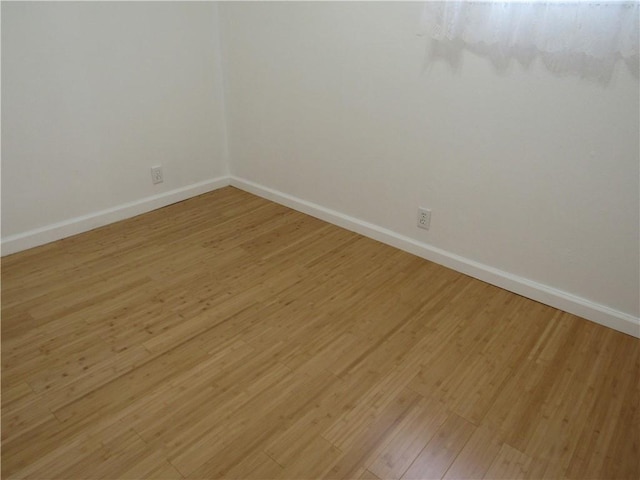 empty room featuring baseboards and light wood-style floors