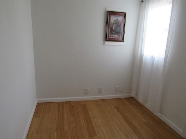 unfurnished room with light wood-type flooring and baseboards