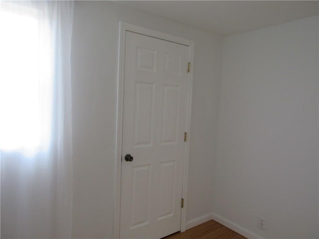 unfurnished room with light wood-style flooring and baseboards