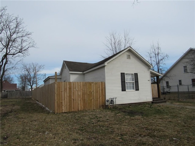 view of home's exterior with a yard and fence