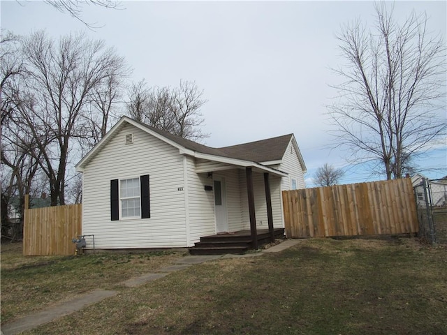 bungalow-style home with fence and a front lawn