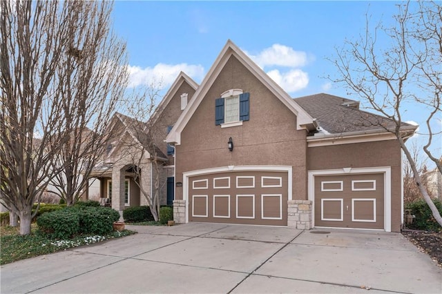 view of front of home with a garage, concrete driveway, and stucco siding