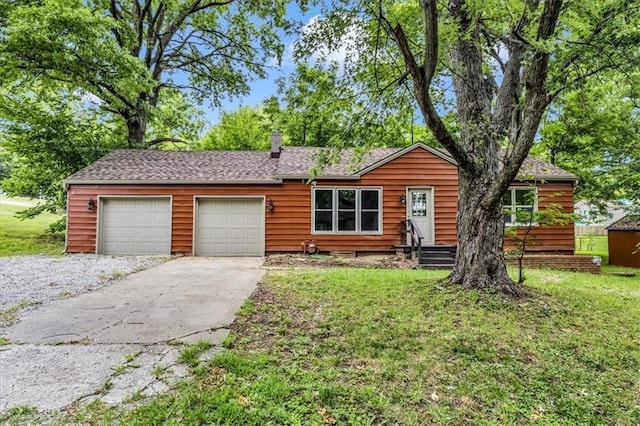 view of front of house featuring a garage, a front yard, driveway, and a shingled roof