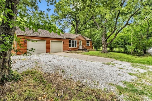 view of front of property featuring an attached garage, driveway, and a front lawn