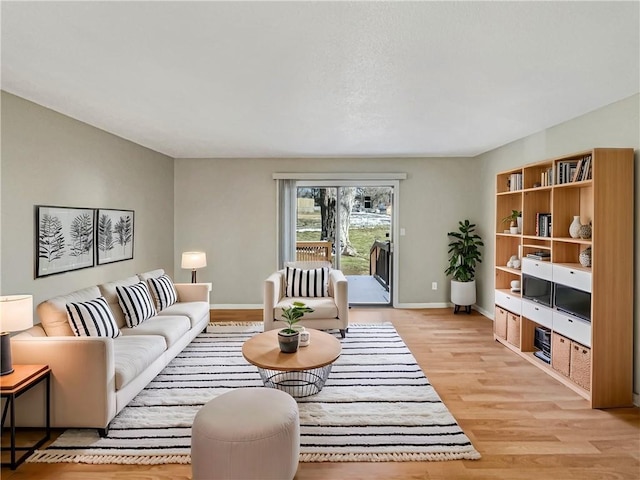 living area featuring light wood-style floors and baseboards