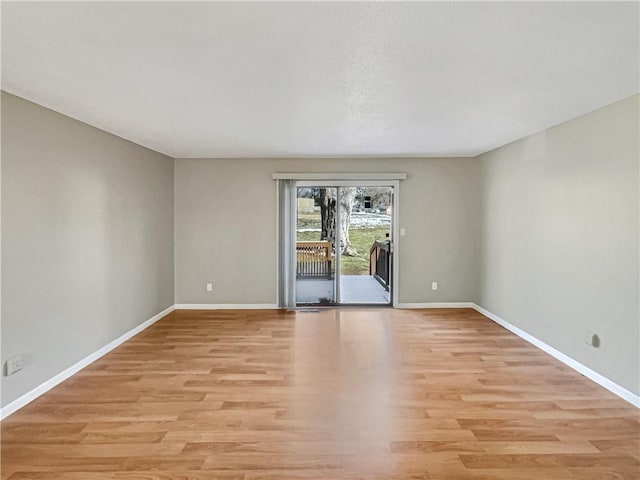 unfurnished room with light wood finished floors and baseboards