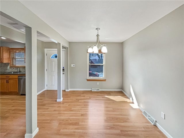 unfurnished dining area featuring light wood finished floors, visible vents, and an inviting chandelier