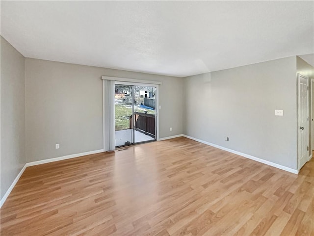 empty room with light wood-type flooring and baseboards