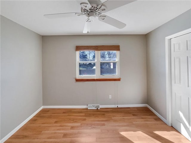 unfurnished room with visible vents, ceiling fan, light wood-style flooring, and baseboards