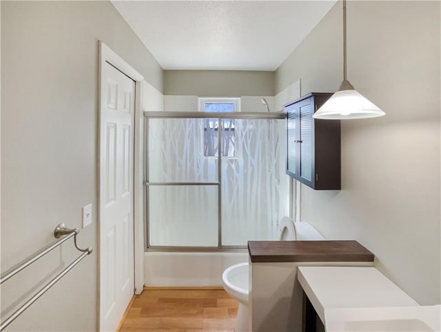 full bath featuring shower / bath combination with glass door, a textured ceiling, wood finished floors, and vanity