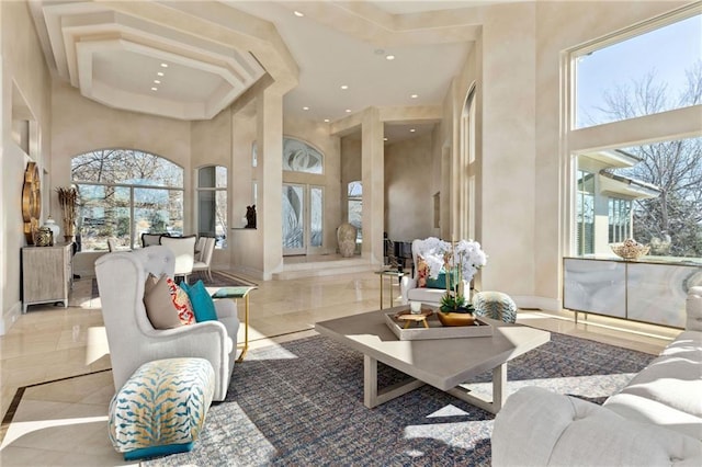 living area featuring a high ceiling and baseboards