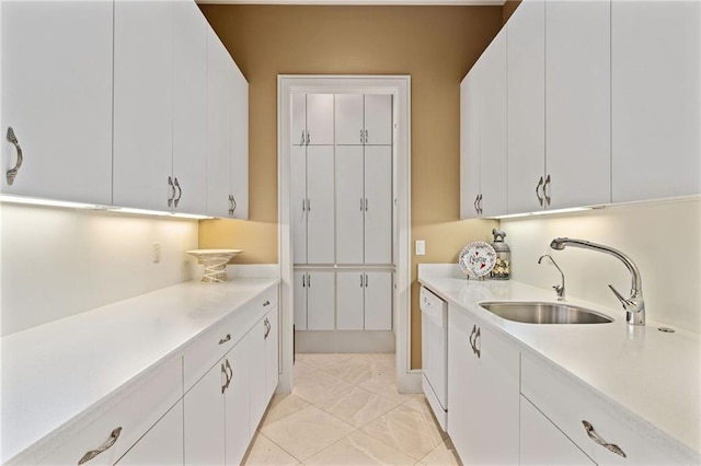 kitchen with light countertops, white dishwasher, a sink, and white cabinets