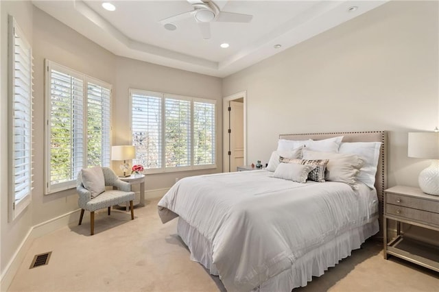 bedroom featuring baseboards, multiple windows, visible vents, and light colored carpet