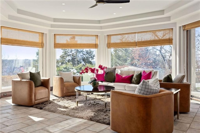 sunroom featuring a tray ceiling and ceiling fan