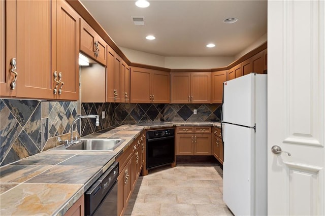 kitchen with a sink, visible vents, tile counters, black appliances, and tasteful backsplash