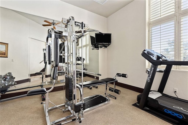 workout area with a ceiling fan and baseboards