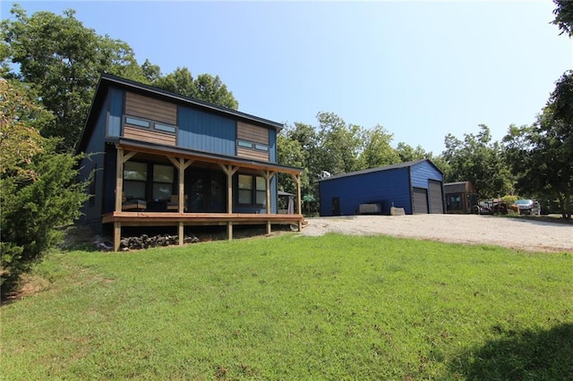 back of property with a yard, a garage, and driveway