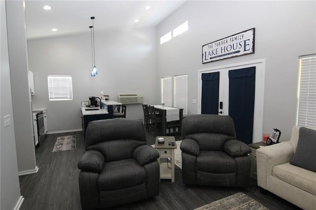 living area featuring baseboards, recessed lighting, a high ceiling, dark wood-style floors, and a wall mounted AC