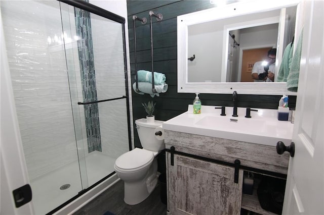 bathroom featuring vanity, toilet, and a shower stall