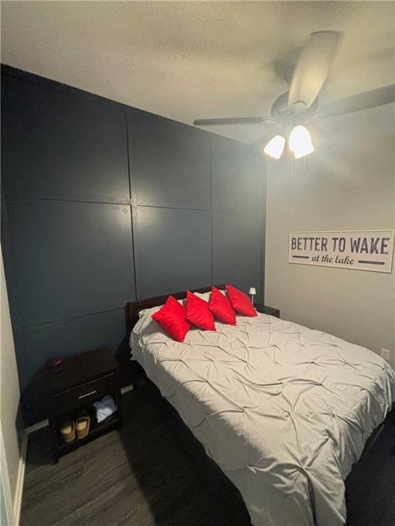 bedroom with ceiling fan, a textured ceiling, and wood finished floors