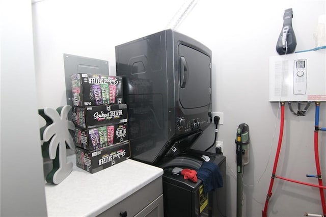 laundry area with stacked washer / drying machine and laundry area