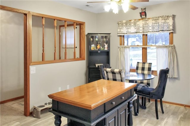 dining room with light wood-style floors, visible vents, ceiling fan, and baseboards