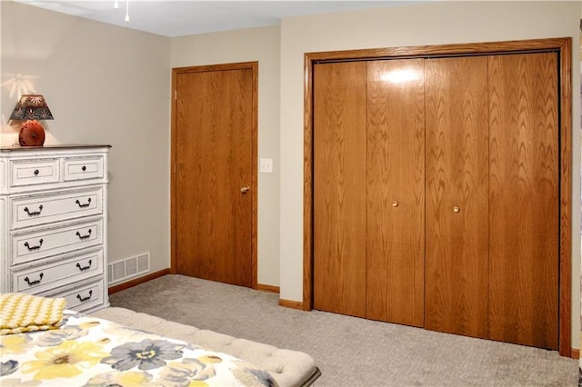 bedroom with carpet floors, baseboards, visible vents, and a closet