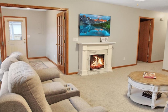 carpeted living area featuring baseboards and a high end fireplace