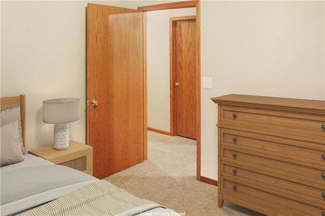 bedroom featuring light carpet and baseboards