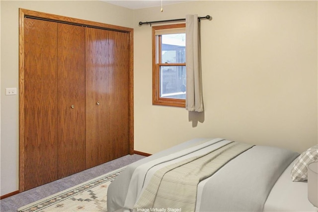 bedroom with a closet, carpet flooring, and baseboards