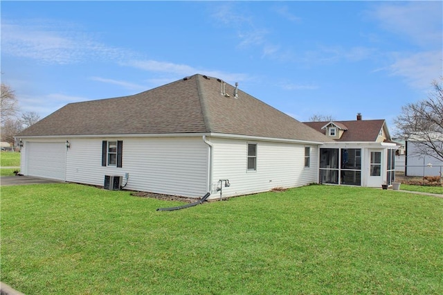 back of property featuring aphalt driveway, cooling unit, a sunroom, a yard, and roof with shingles