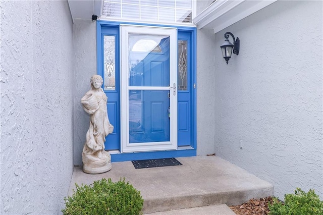 doorway to property featuring stucco siding