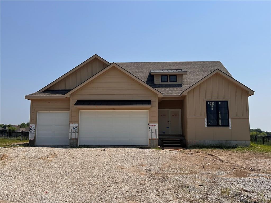 2341 Fishing Ln, Kearney, MO 64060 - view of front facade featuring board and batten siding, an attached garage, roof with shingles, and driveway