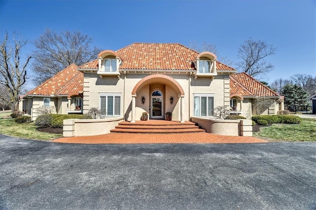 mediterranean / spanish-style home with stucco siding and a tiled roof