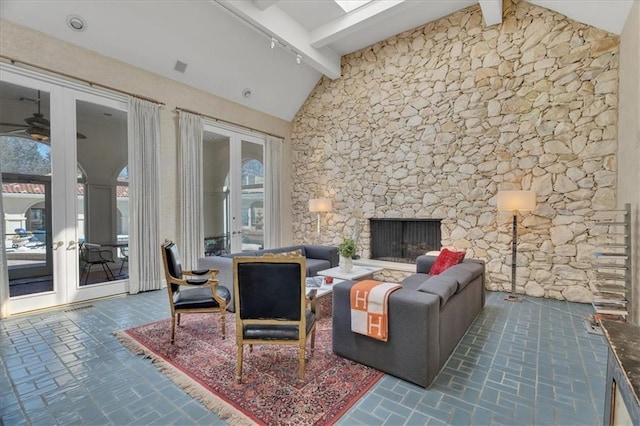 living room with a ceiling fan, high vaulted ceiling, a fireplace, brick floor, and beamed ceiling