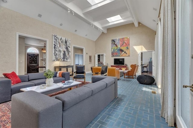 living area featuring beamed ceiling, brick floor, and high vaulted ceiling