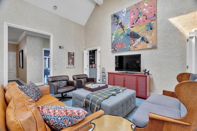 living room with baseboards, visible vents, high vaulted ceiling, beam ceiling, and a textured wall