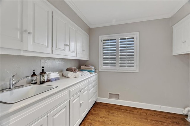 kitchen with white cabinetry, visible vents, and a sink