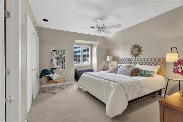 bedroom with a ceiling fan, baseboards, and light carpet